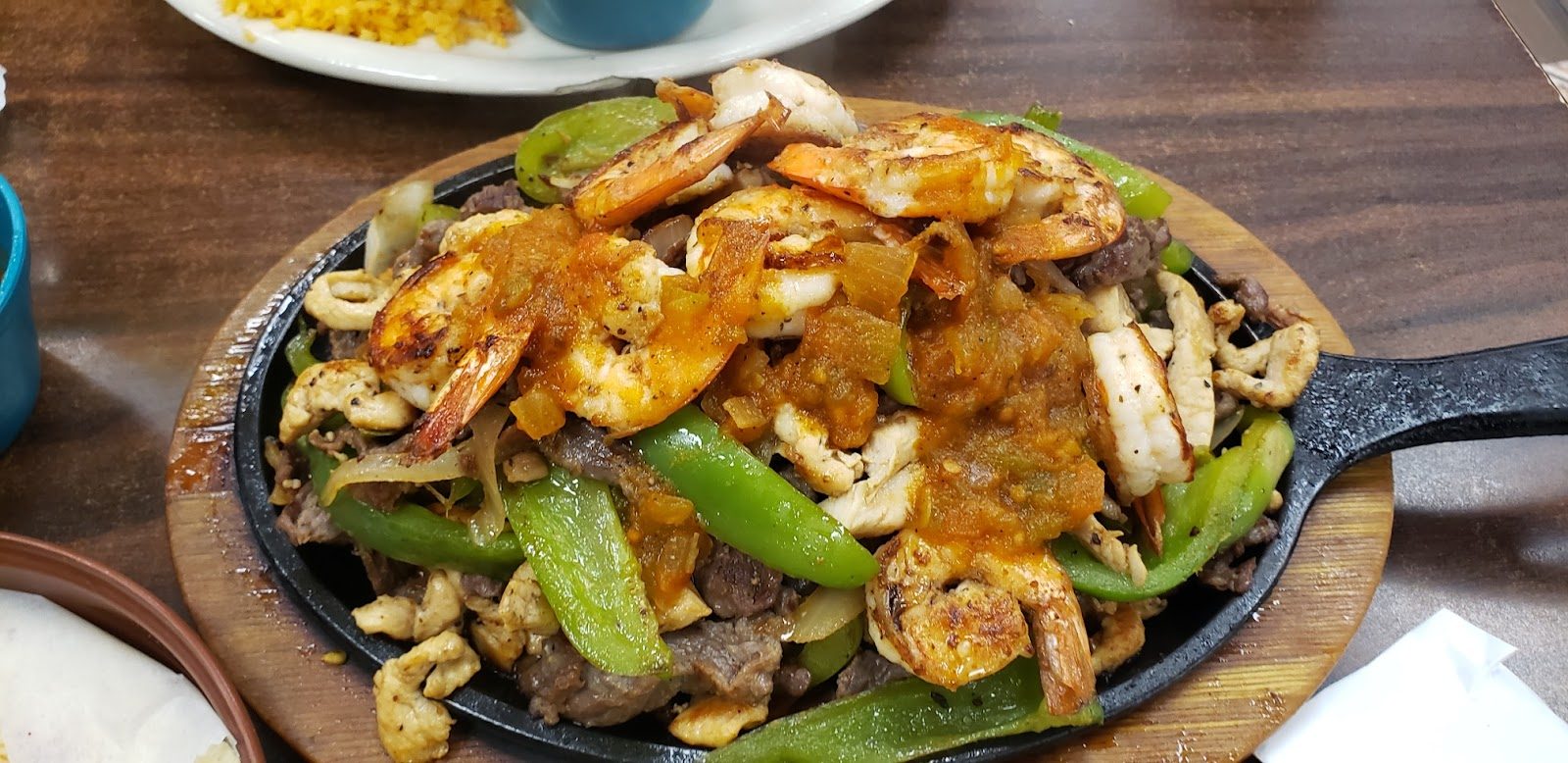 Sizzling skillet of fajitas with shrimp, peppers and onions