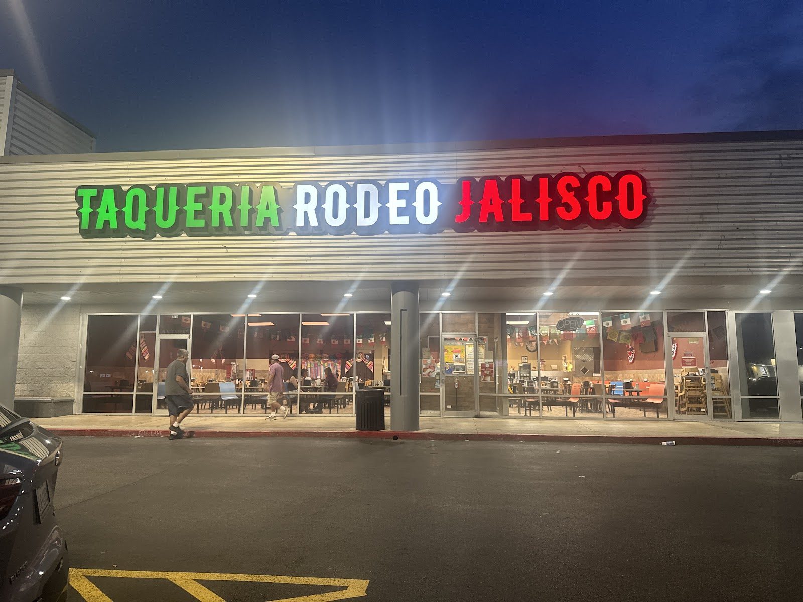 Lit Taqueria Rodeo Jalisco sign over the storefront at night